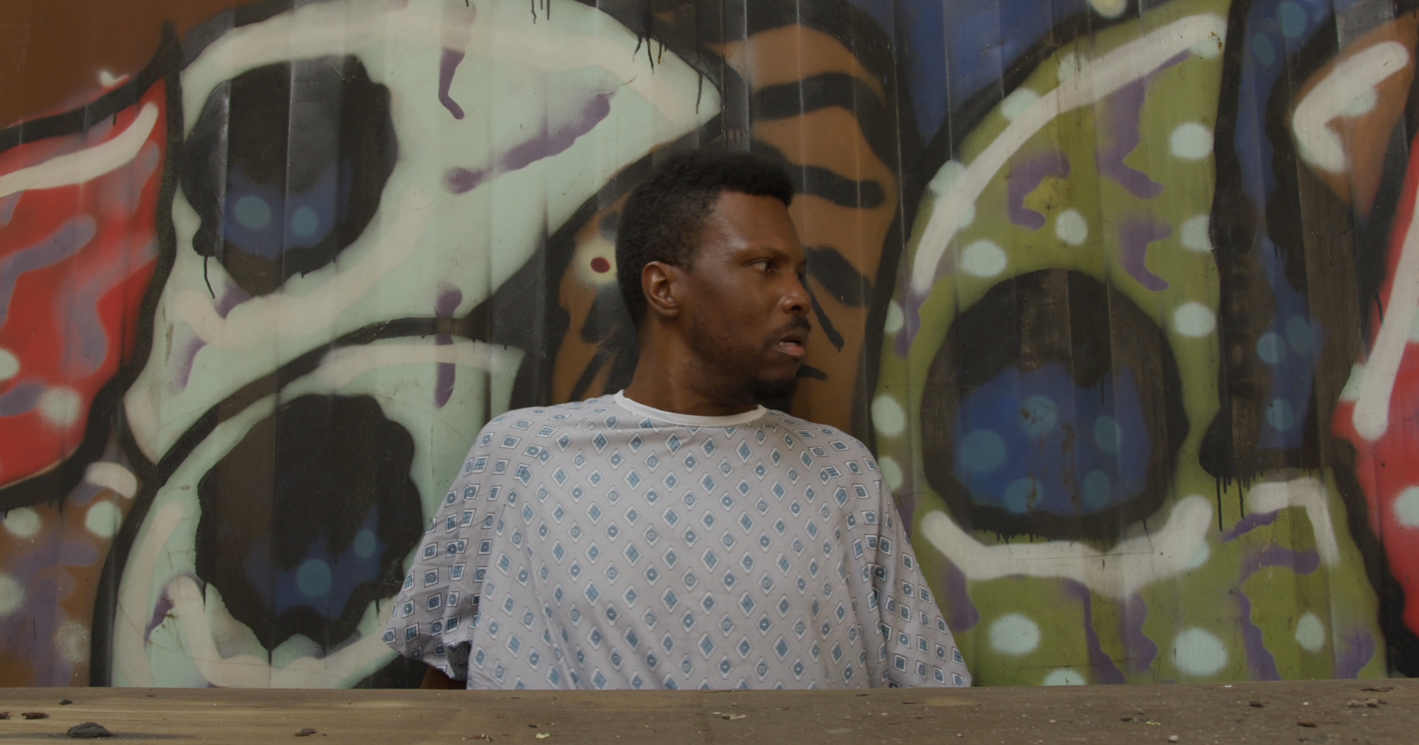 D!SoRd3rEd — hospital gown against graffiti wall